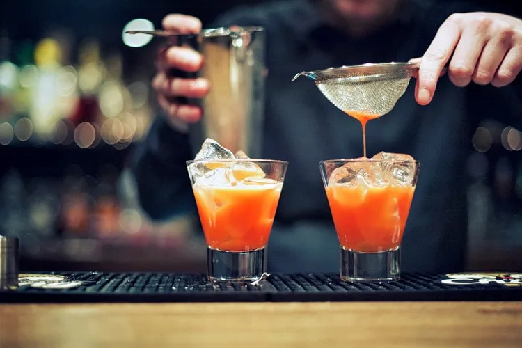 Barmen iki kokteyli süzerek hazırlıyor: kalite, malzeme kadar ustalıktır